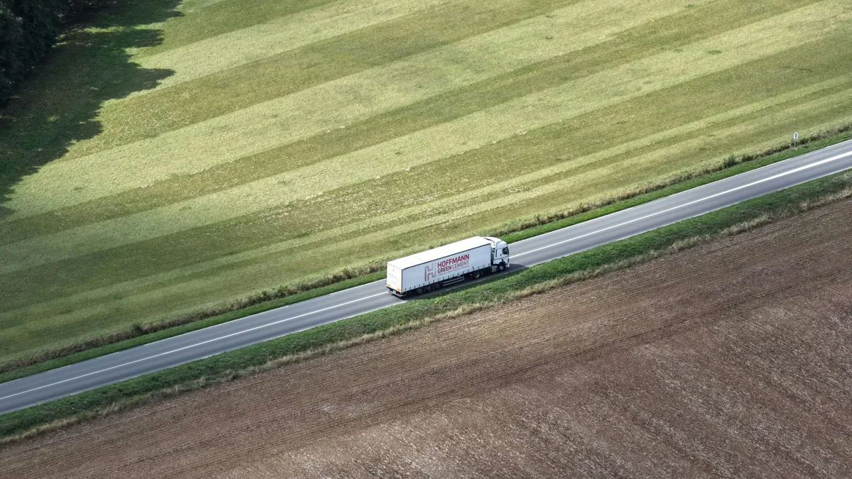 Lkw auf einer Landstraße zwischen Feldern von oben